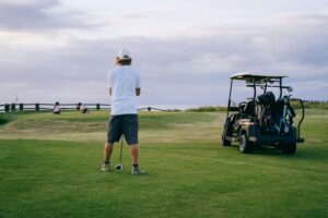 Are Golf Carts Street Legal - a man standing in front of a golf cart